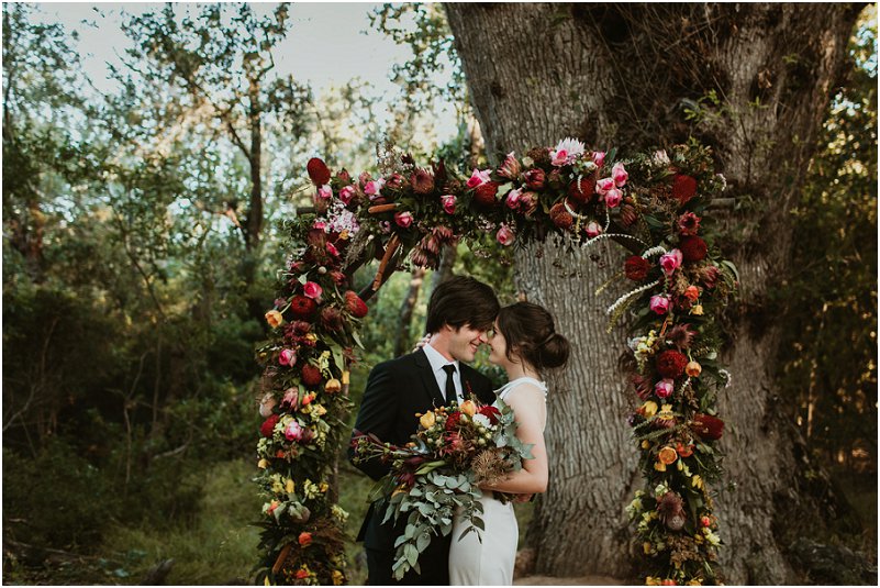 bridal couple infront of flowers